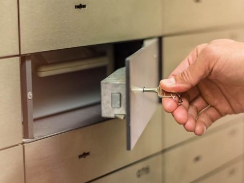 Hand, die ein Kundenmietfach öffnet